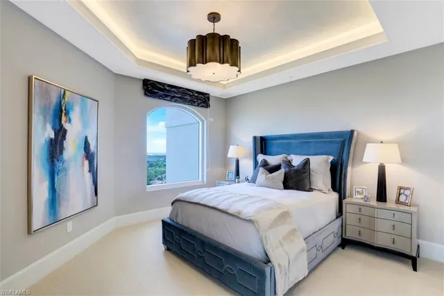 a bedroom with a large bed and a chandelier