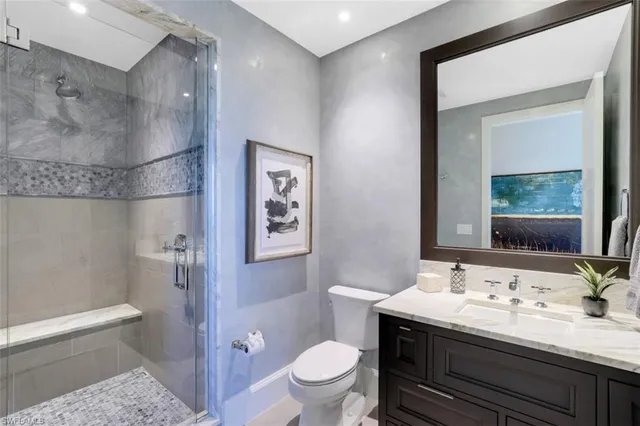 a bathroom with a granite countertop sink toilet a large mirror and shower