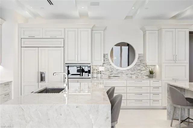 a kitchen with granite countertop a white cabinets and a sink
