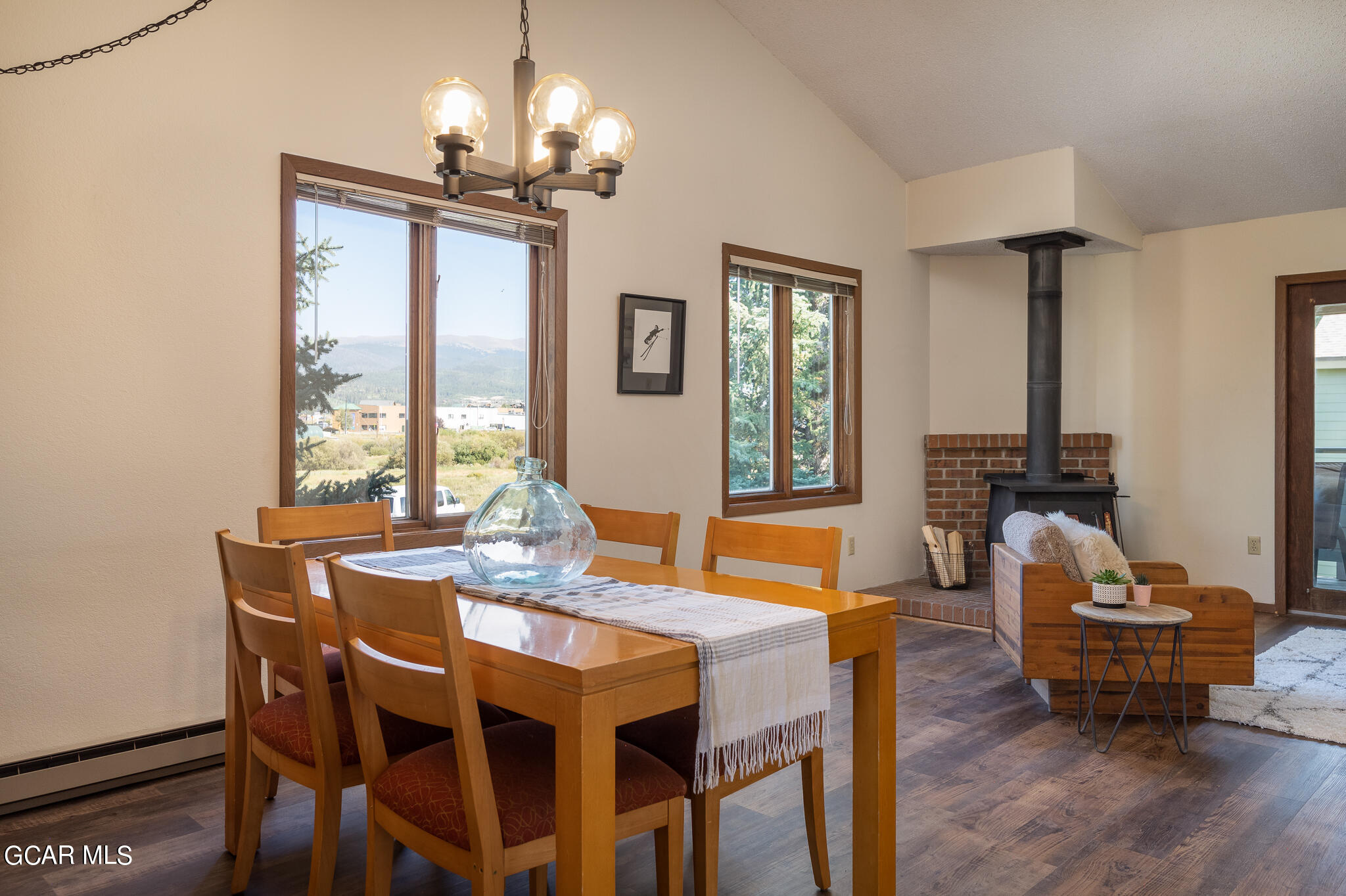 99 Doc Susie Avenue, Unit B6 Fraser, CO 80442 - Photo 6 of 24 a dining room with wooden floor a chandelier a wooden table and chairs