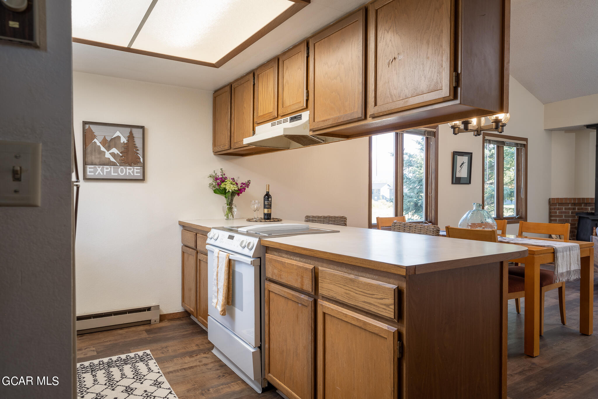 99 Doc Susie Avenue, Unit B6 Fraser, CO 80442 - Photo 8 of 24 a kitchen with stainless steel appliances granite countertop a sink and dishwasher a stove with wooden cabinets
