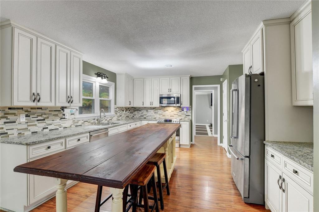 2610 Loring Road Northwest Kennesaw, GA 30152 - Photo 11 of 28 a kitchen with stainless steel appliances granite countertop a stove refrigerator and a view of living room