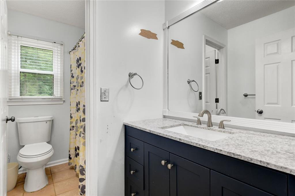2610 Loring Road Northwest Kennesaw, GA 30152 - Photo 21 of 28 a bathroom with a granite countertop sink toilet and shower