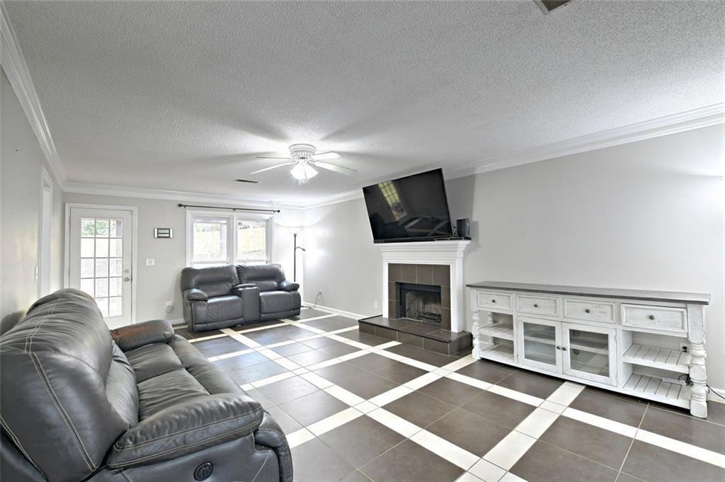2610 Loring Road Northwest Kennesaw, GA 30152 - Photo 5 of 28 a living room with furniture a flat screen tv and a fireplace
