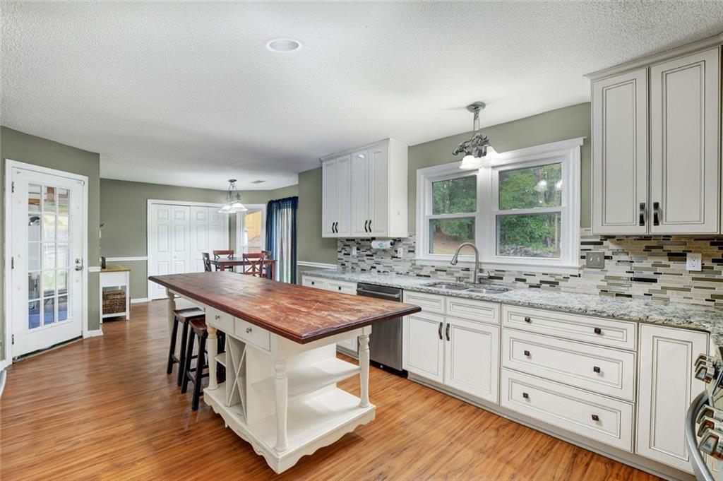 2610 Loring Road Northwest Kennesaw, GA 30152 - Photo 9 of 28 a open kitchen with stainless steel appliances granite countertop a stove and a wooden floors