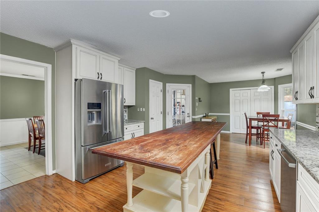 2610 Loring Road Northwest Kennesaw, GA 30152 - Photo 10 of 28 a dining hall with stainless steel appliances granite countertop a table chairs and a refrigerator