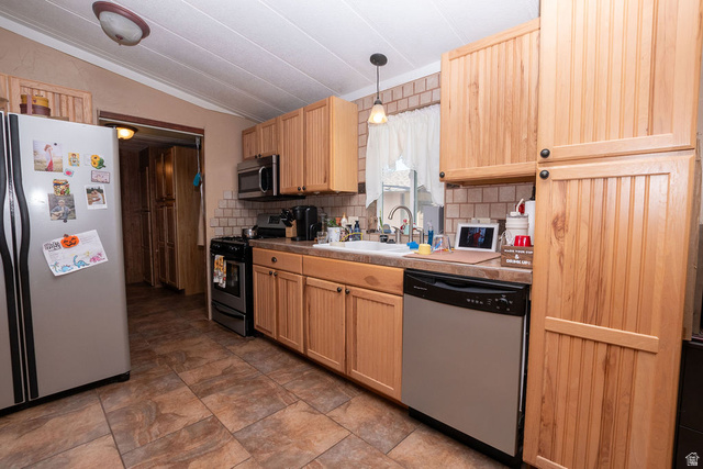 855 East 300 N Street Beaver, UT 84713 - Photo 27 of 44 Kitchen featuring wood cabinetry, stainless steel appliances, a tile backsplash, durable tile flooring, and a window above the sink