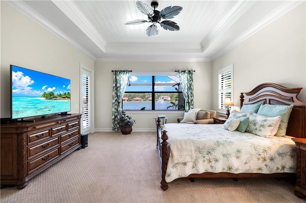 1456 Mockingbird Drive Naples, FL 34120 - Photo 21 of 43 Bedroom featuring light colored carpet, multiple windows, ornamental molding, a raised ceiling, and a ceiling fan