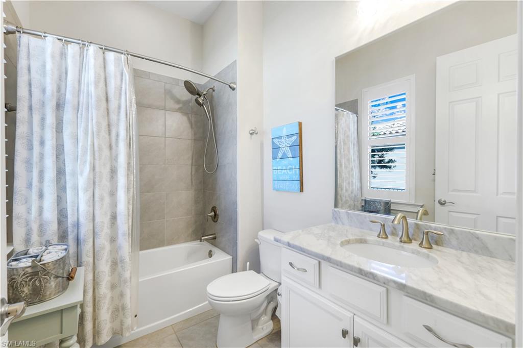 1456 Mockingbird Drive Naples, FL 34120 - Photo 26 of 43 Bathroom with shower / bathtub combination with curtain, vanity, and light tile patterned floors