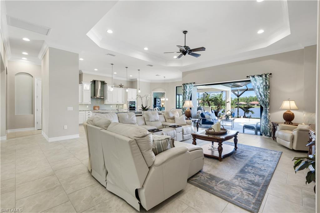 1456 Mockingbird Drive Naples, FL 34120 - Photo 6 of 43 Living area featuring a tray ceiling, arched walkways, ornamental molding, recessed lighting, and ceiling fan