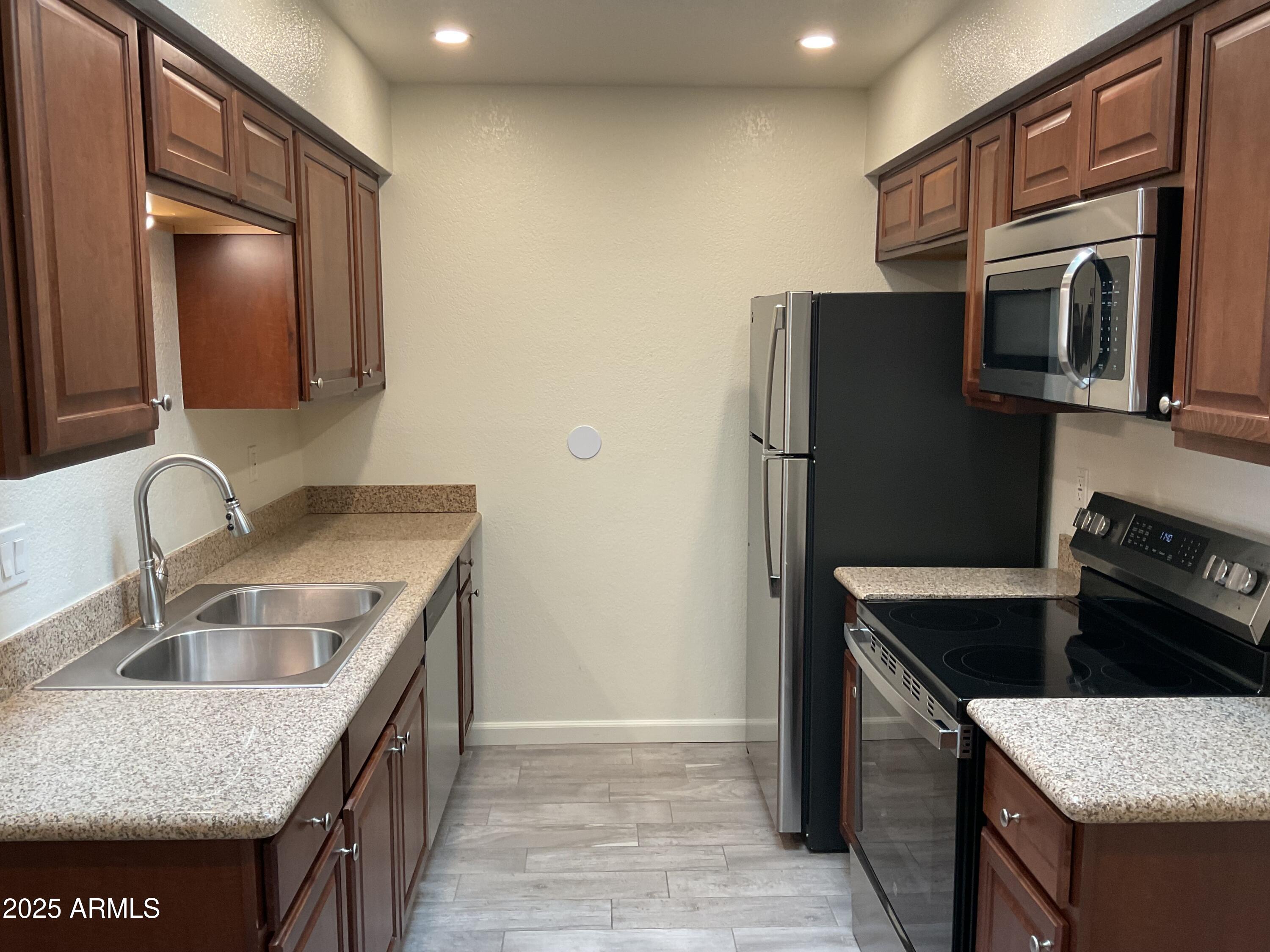 95 North Cooper Road, Unit 75 Chandler, AZ 85225 - Photo 3 of 19 a kitchen with stainless steel appliances granite countertop a sink stove and refrigerator
