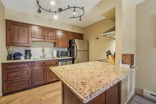 a kitchen with granite countertop cabinets and refrigerator