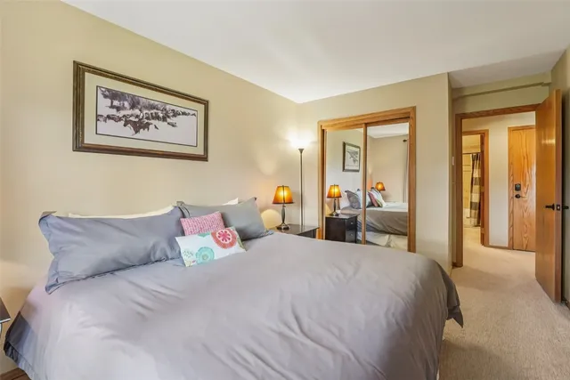 a bedroom with a bed and a large mirror