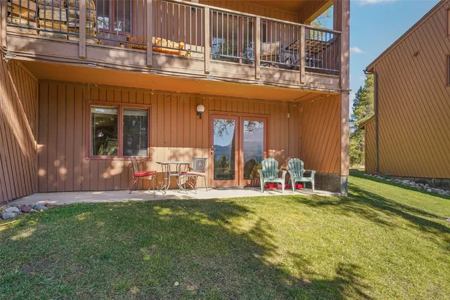 a view of a chairs and table in the back yard of the house