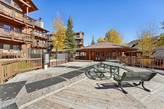 a view of a patio with couches table and chairs under an umbrella