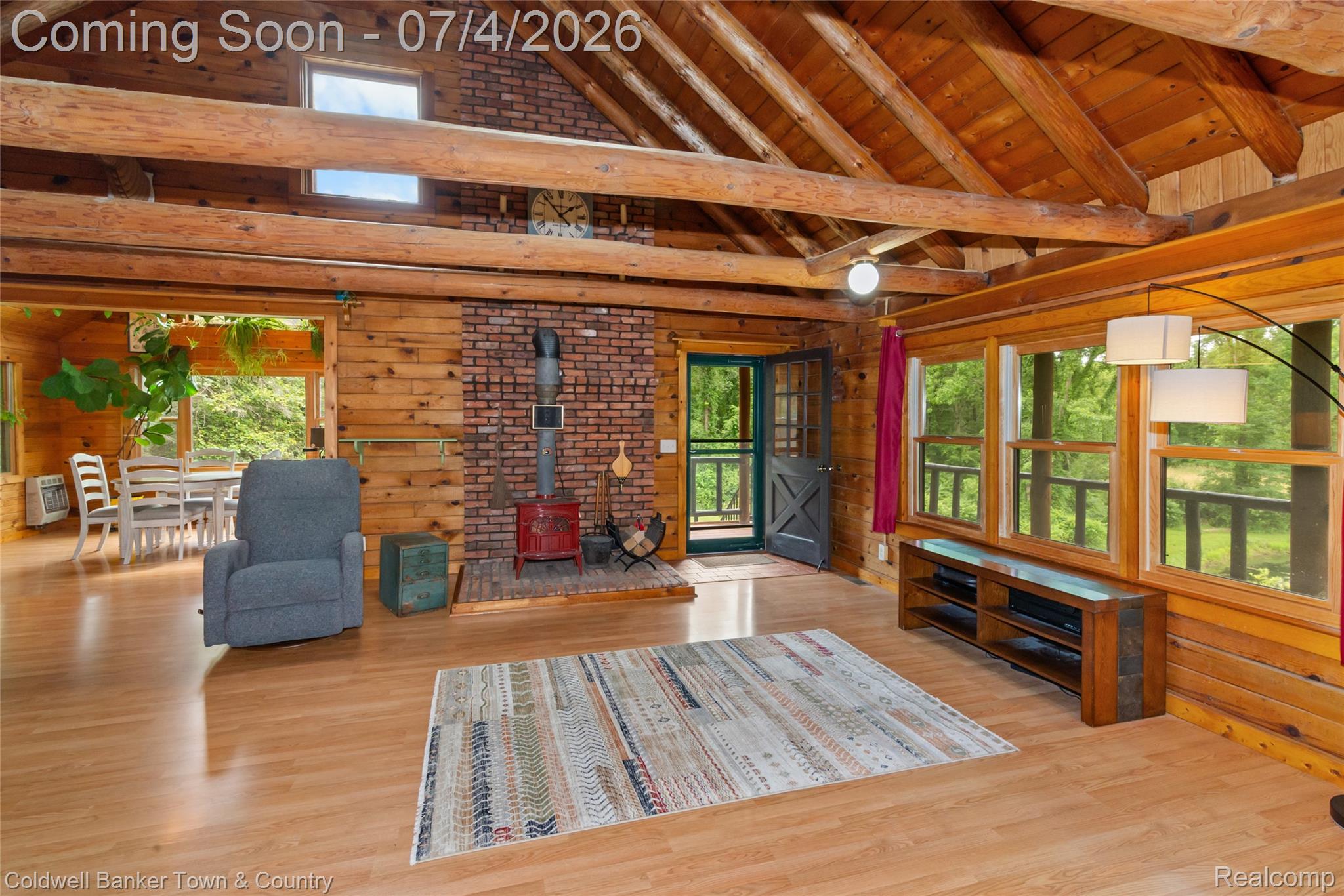 7335 Richardson Road Howell, MI 48843 - Photo 22 of 54 Open-concept living area featuring exposed wood beams, wood plank walls, and wood-finish flooring