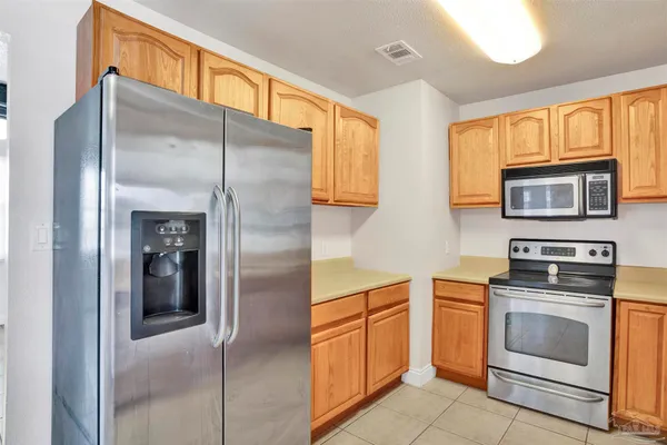 a kitchen with stainless steel appliances granite countertop a refrigerator and a stove top oven