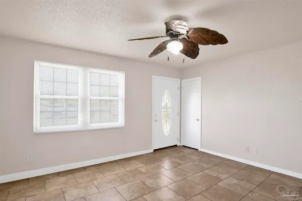 an empty room with windows and fan