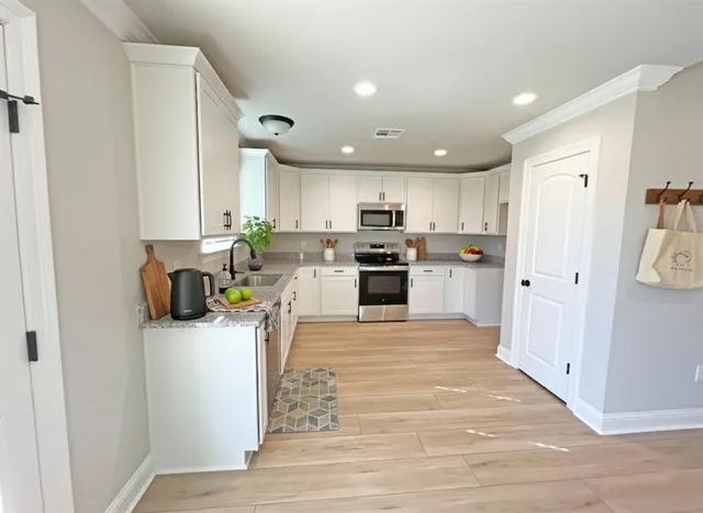 a kitchen with stainless steel appliances granite countertop a refrigerator sink and cabinets