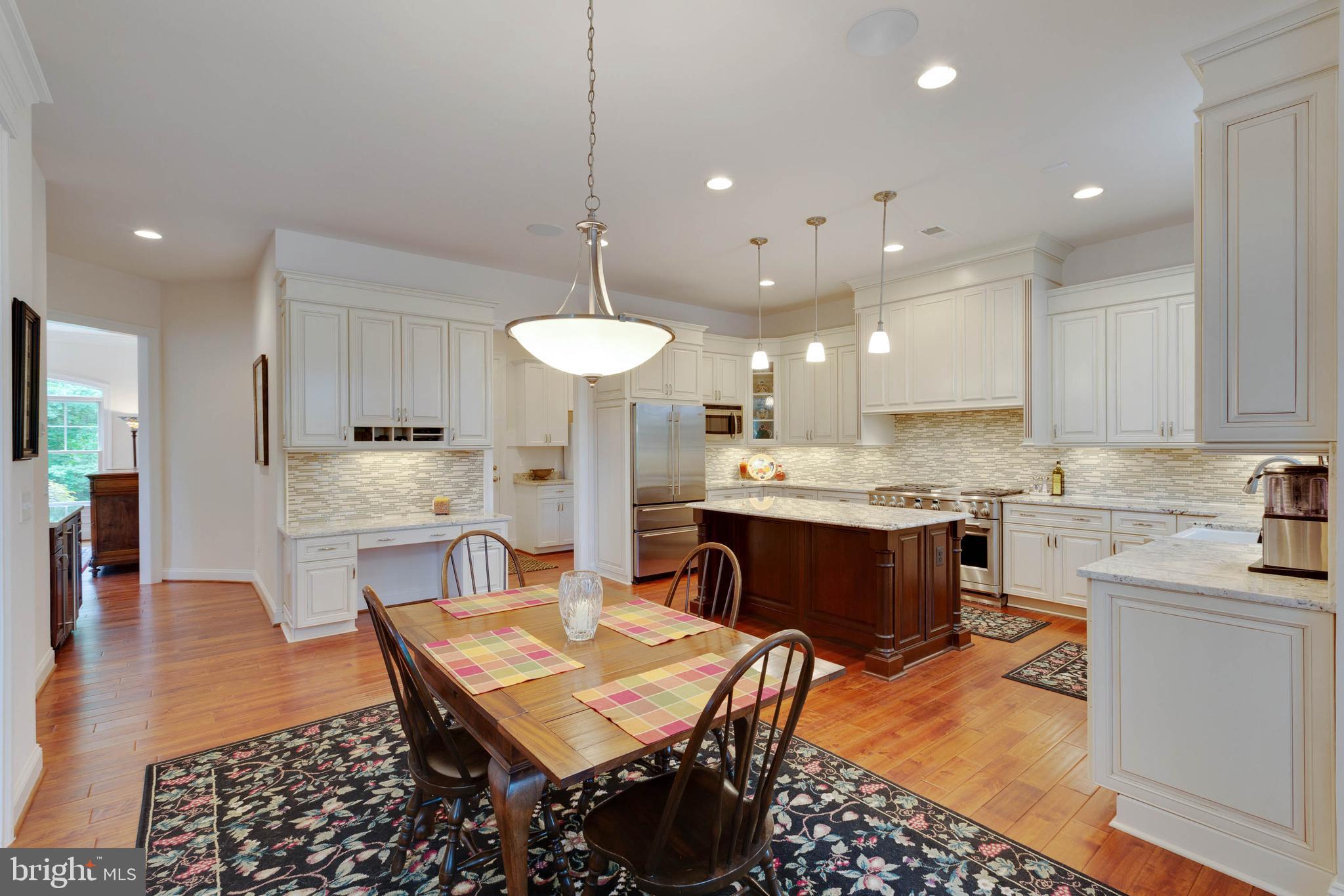 3003 Weber Place Oakton, VA 22124 - Photo 17 of 63 a large kitchen with kitchen island a sink a stove a dining table and chairs