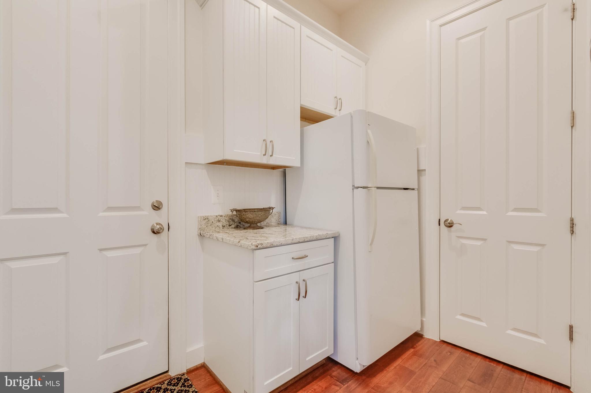 3003 Weber Place Oakton, VA 22124 - Photo 23 of 63 a kitchen with white cabinets and white appliances