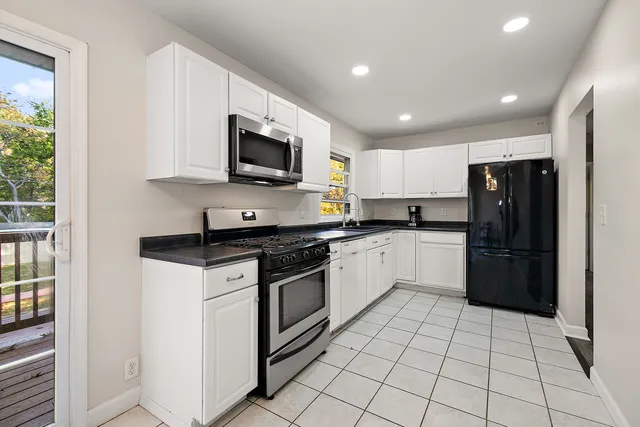 a kitchen with stainless steel appliances granite countertop a refrigerator and a stove top oven