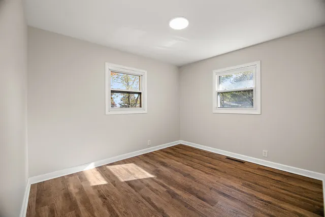 a view of room with window and wooden floor