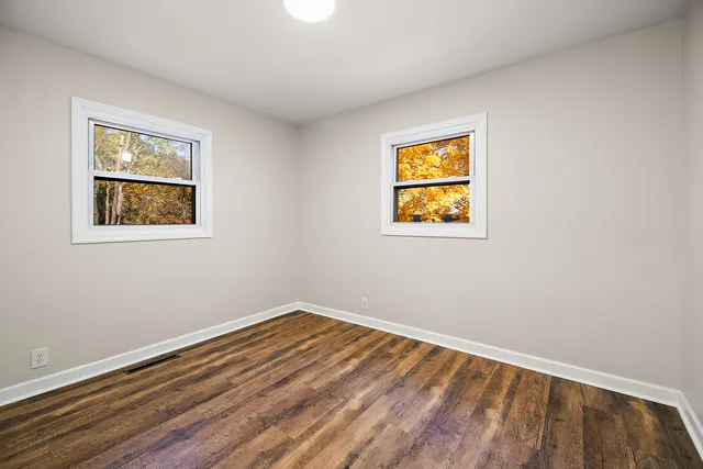 a view of room with window and wooden floor
