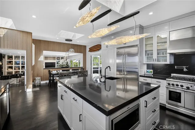 a kitchen with a granite countertop sink stove and cabinets