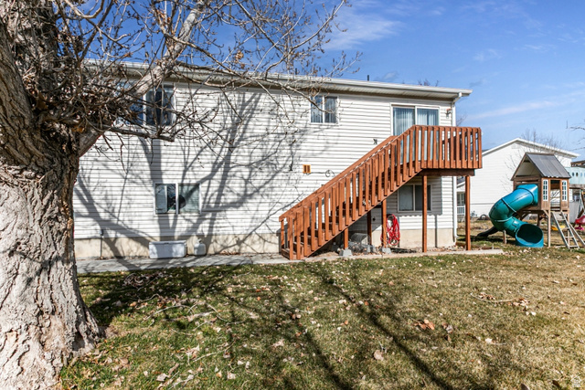 4239 West 5325th Street South Roy, UT 84067 - Photo 24 of 26 Rear view of property featuring a lawn and a playground