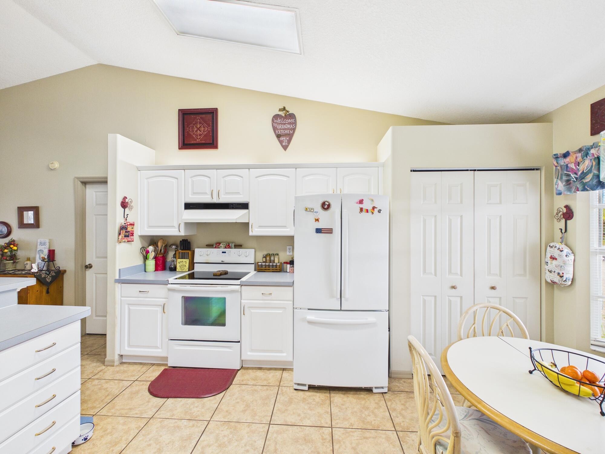 8525 Southwest 9th Street Okeechobee, FL 34974 - Photo 12 of 67 a kitchen with stainless steel appliances a refrigerator and a stove top oven