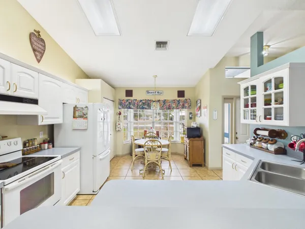 a view of a dining room with furniture one side kitchen view and a chandelier