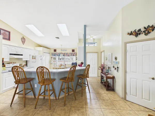 a living room with furniture kitchen view and a chandelier