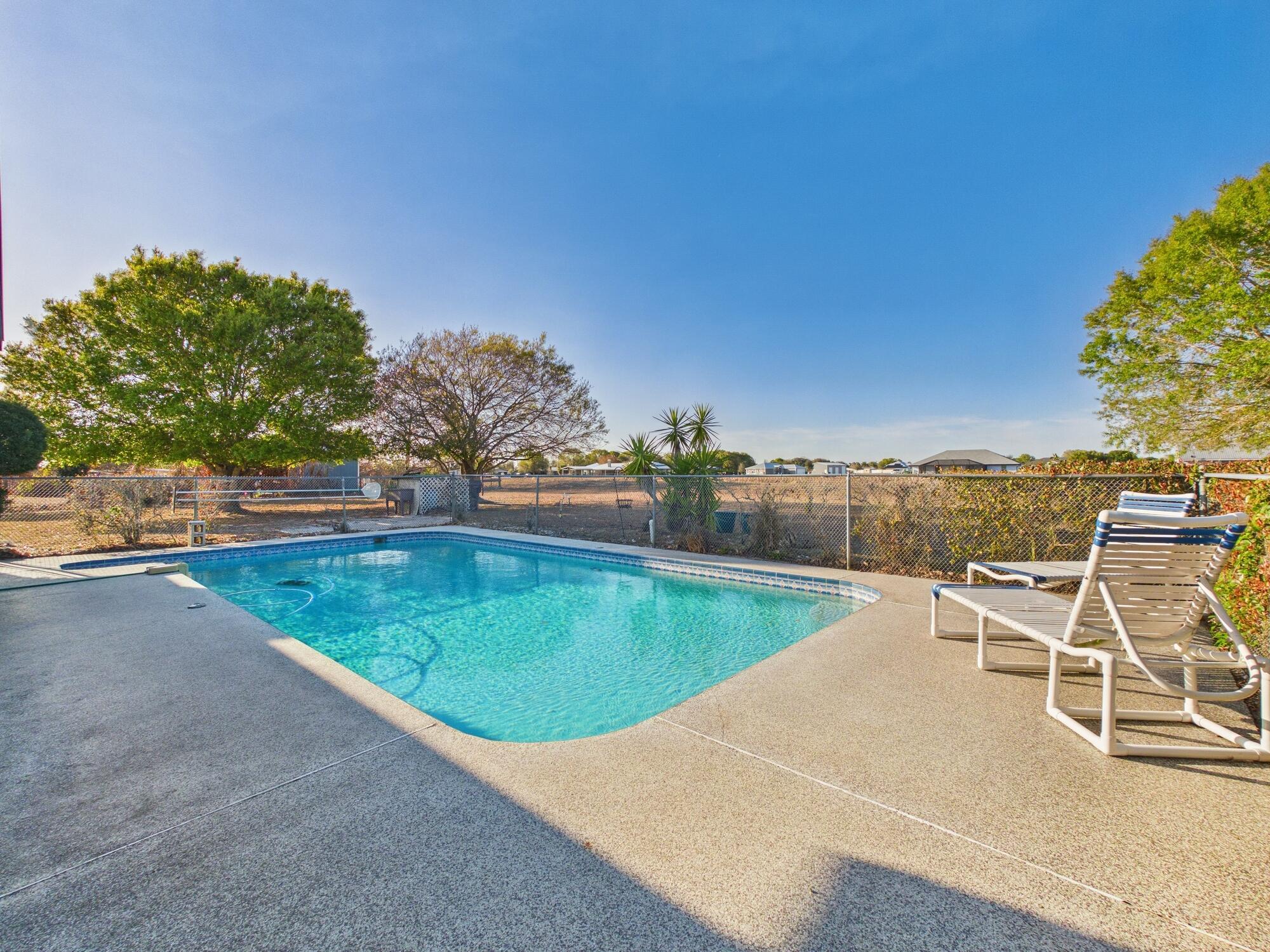8525 Southwest 9th Street Okeechobee, FL 34974 - Photo 2 of 67 a view of a swimming pool with a lounge chair