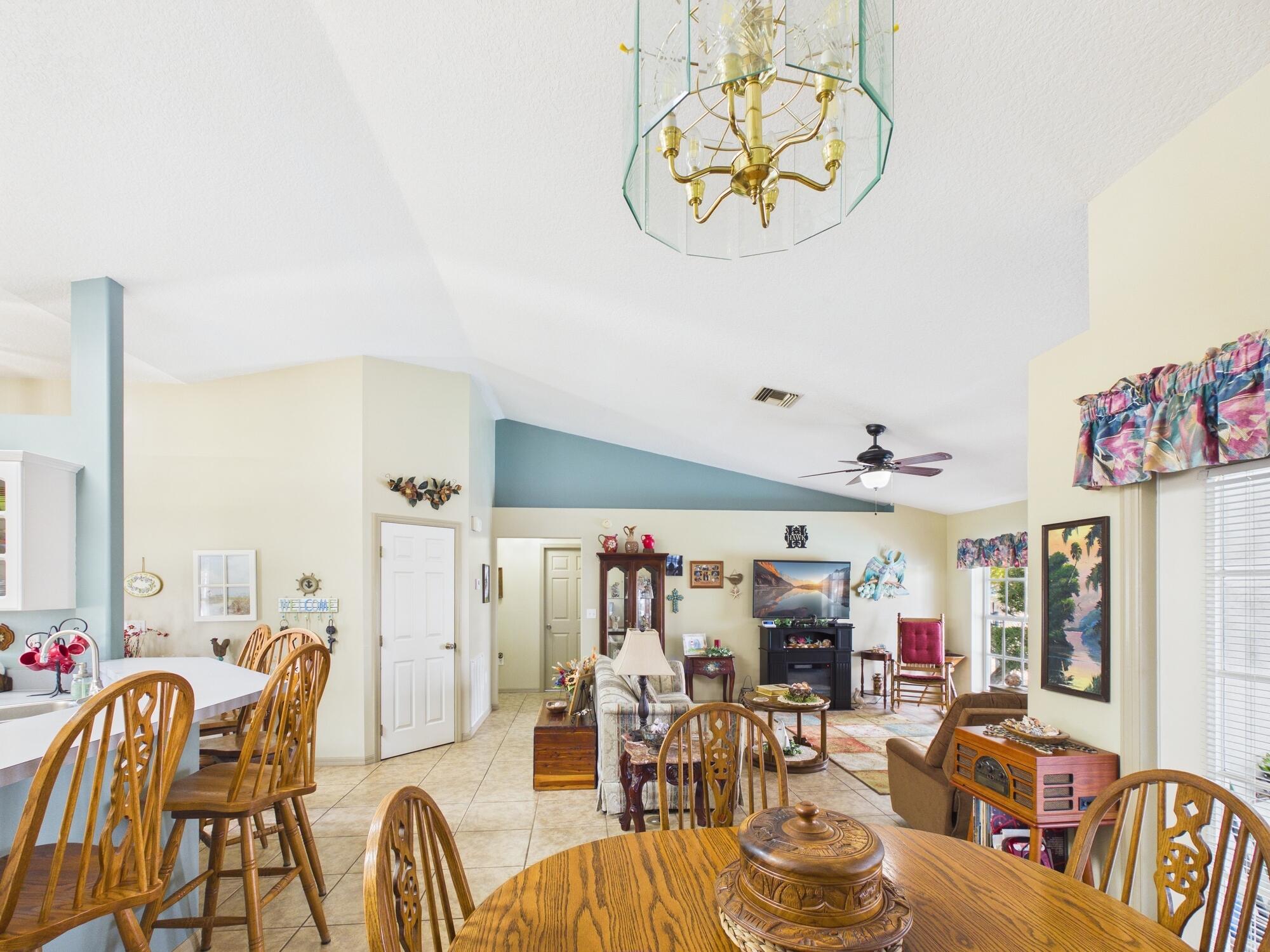 8525 Southwest 9th Street Okeechobee, FL 34974 - Photo 23 of 67 a view of a dining room with furniture one side kitchen view and a chandelier