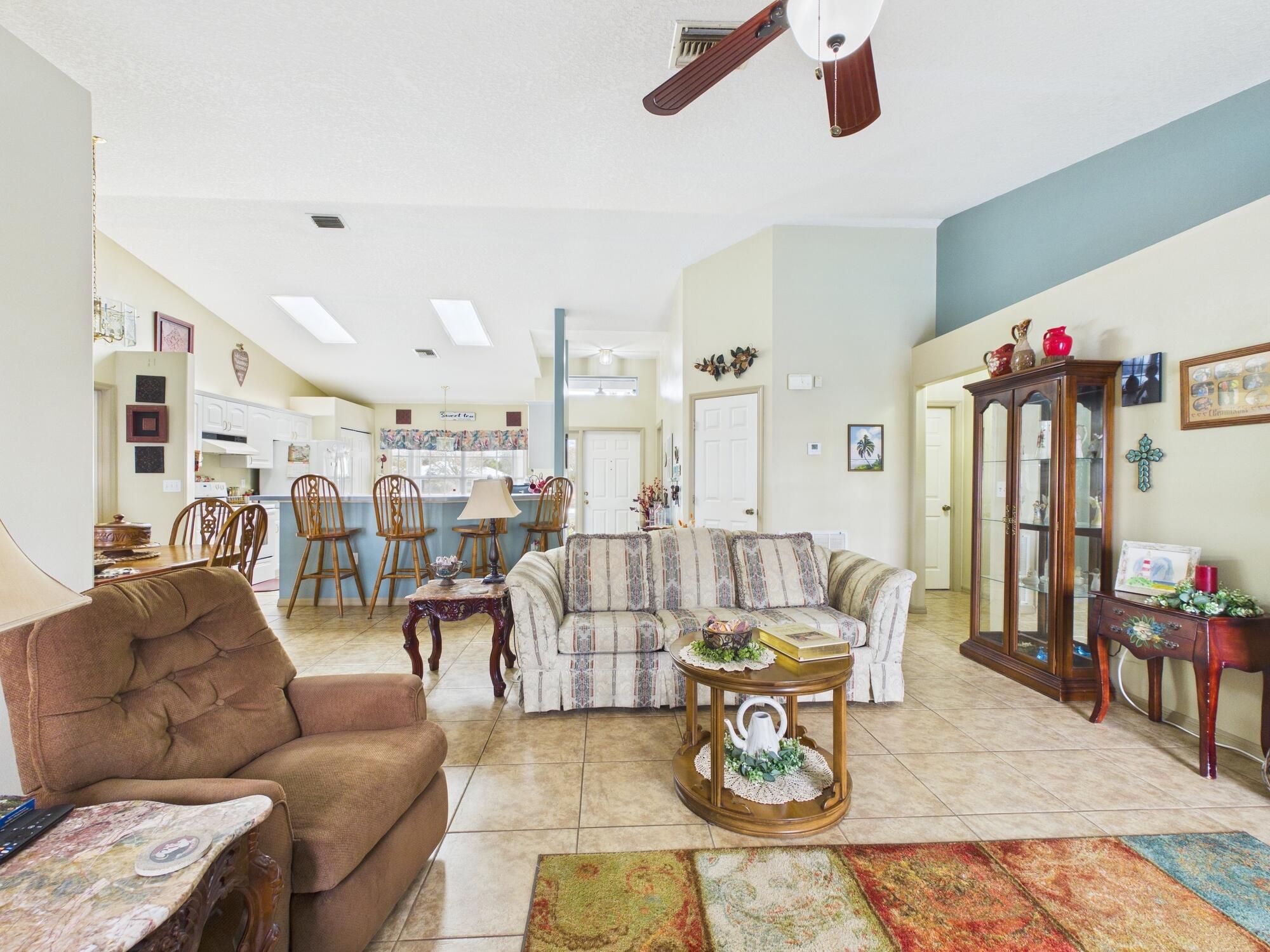 8525 Southwest 9th Street Okeechobee, FL 34974 - Photo 26 of 67 a living room with furniture kitchen view and a chandelier