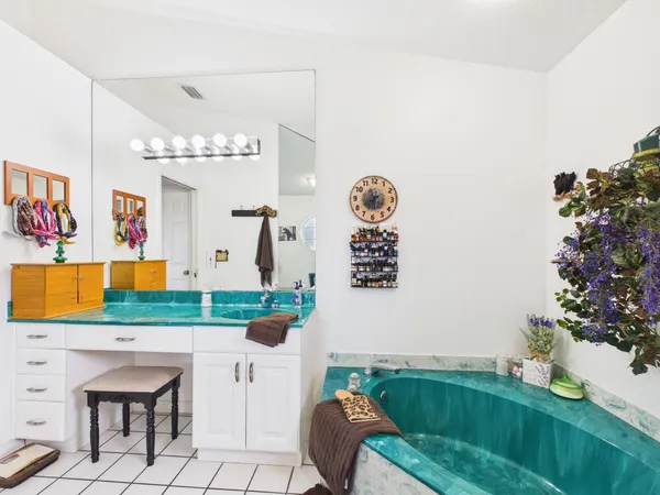 a view of house with a yard and a large parking space