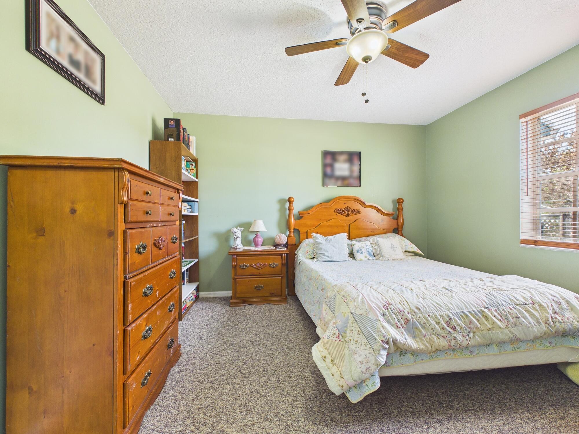 8525 Southwest 9th Street Okeechobee, FL 34974 - Photo 45 of 67 a bedroom with a bed and a chandelier