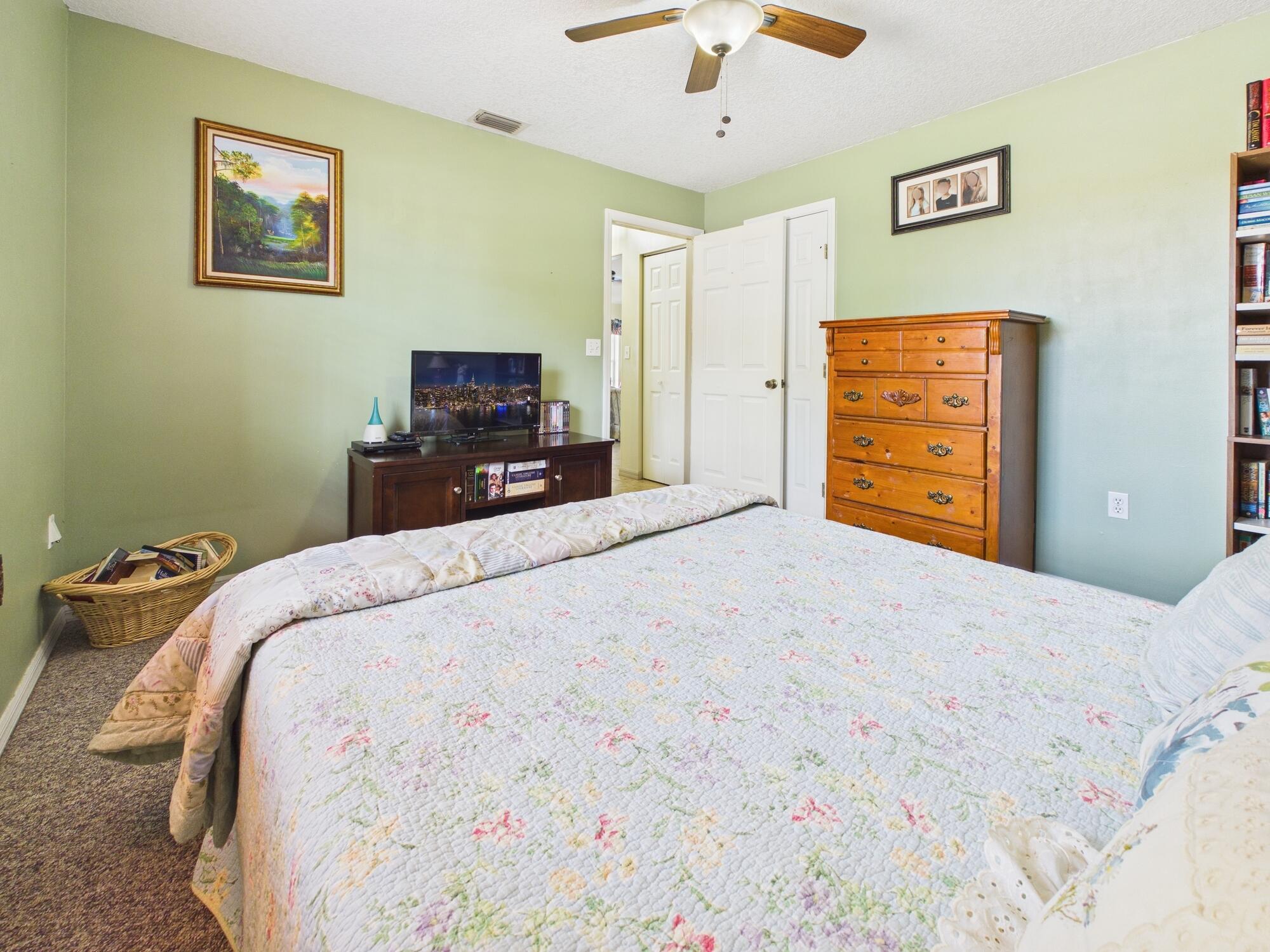 8525 Southwest 9th Street Okeechobee, FL 34974 - Photo 47 of 67 a bedroom with a bed and a chandelier