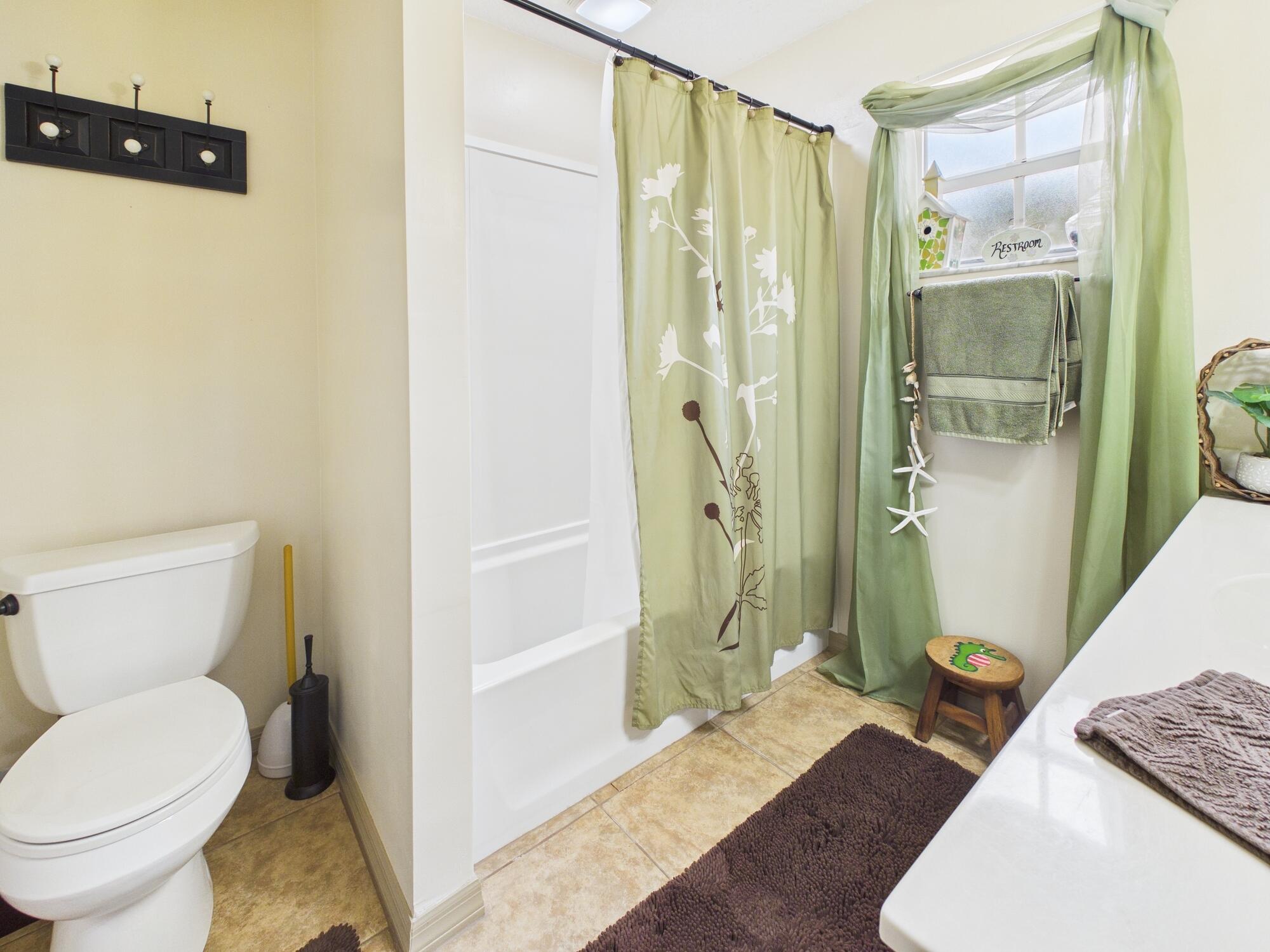 8525 Southwest 9th Street Okeechobee, FL 34974 - Photo 49 of 67 a bathroom with a granite countertop shower and a toilet
