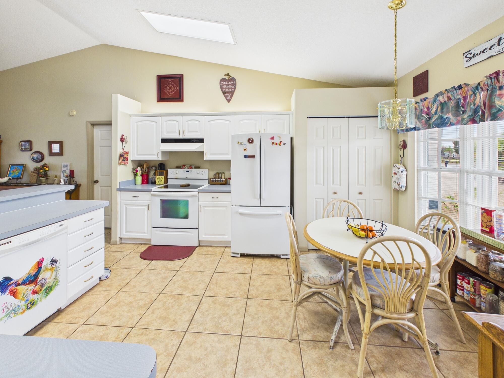 8525 Southwest 9th Street Okeechobee, FL 34974 - Photo 10 of 67 a kitchen with stainless steel appliances kitchen island granite countertop a refrigerator and a stove top oven