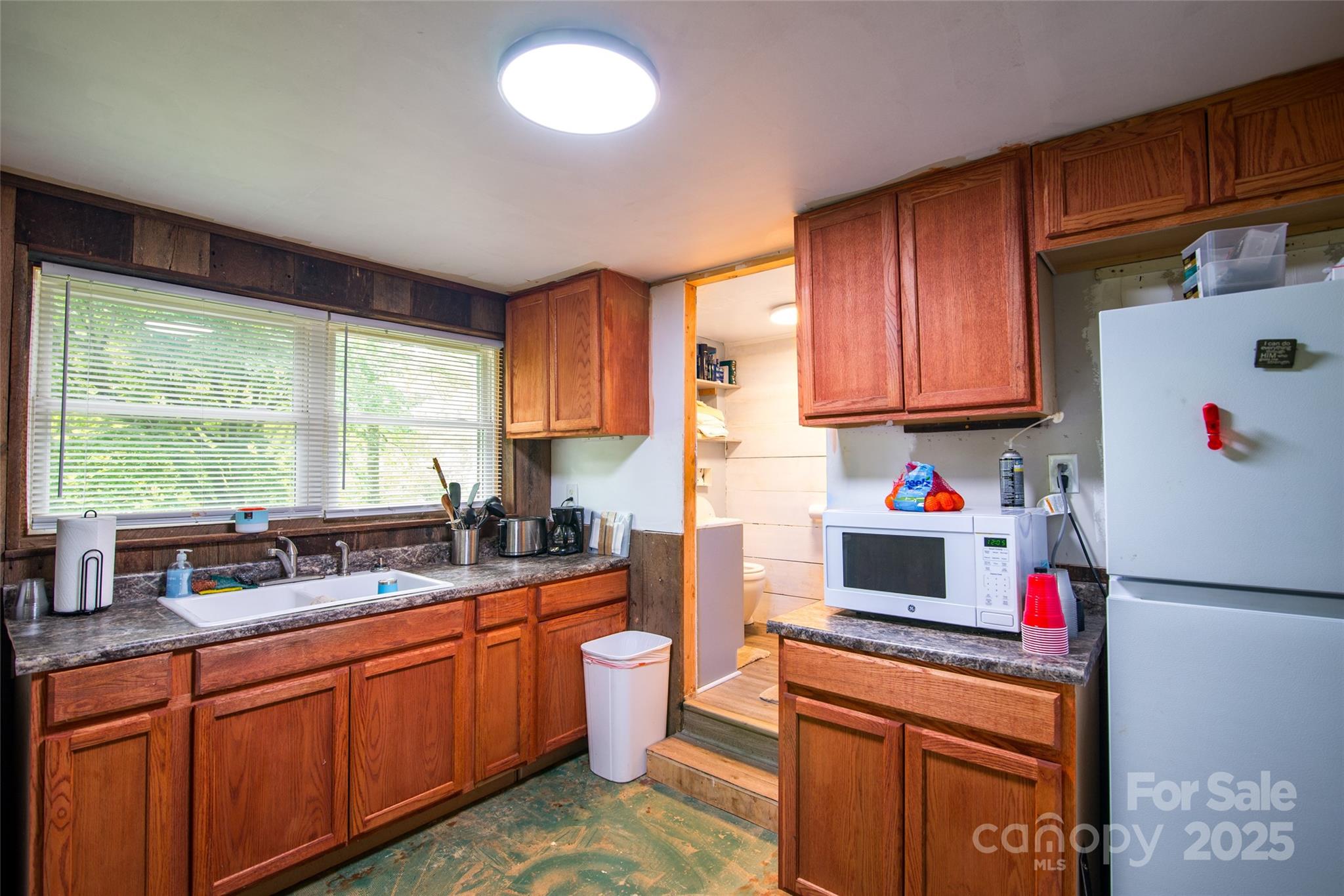 220 Frosty Ridge Road Sylva, NC 28779 - Photo 17 of 32 a kitchen with granite countertop a refrigerator sink stove and cabinets