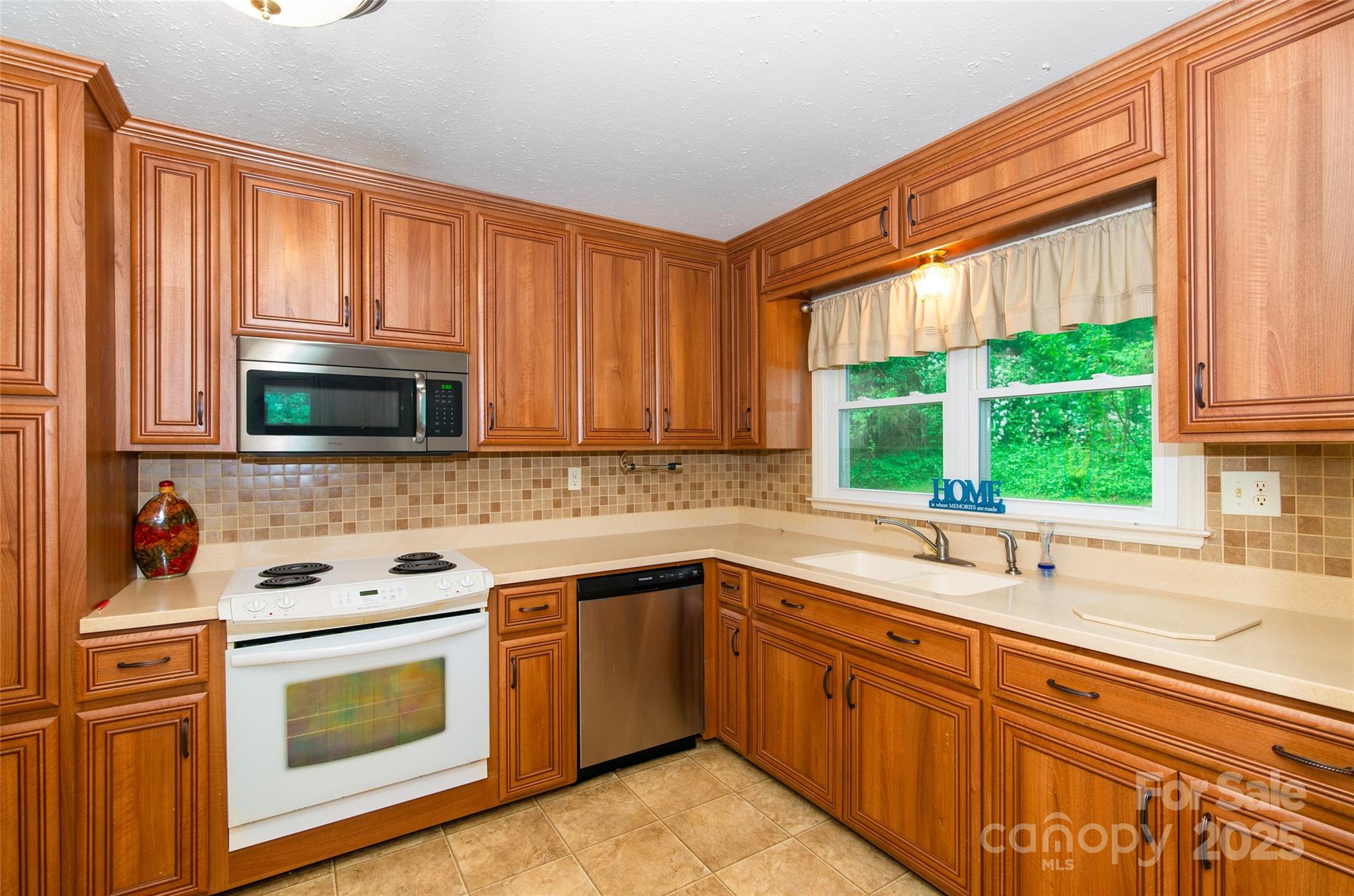 220 Frosty Ridge Road Sylva, NC 28779 - Photo 7 of 32 a kitchen with stainless steel appliances a sink stove and microwave