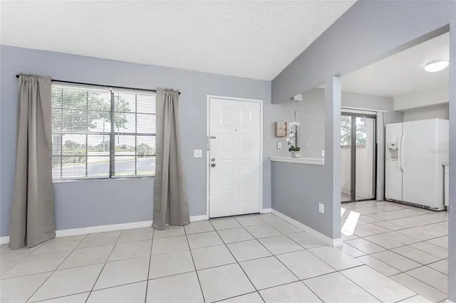 a view of an empty room with window and cabinet