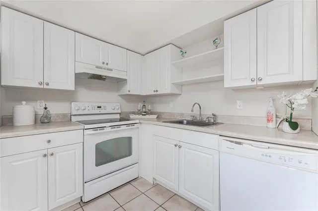 a kitchen with white cabinets and white appliances