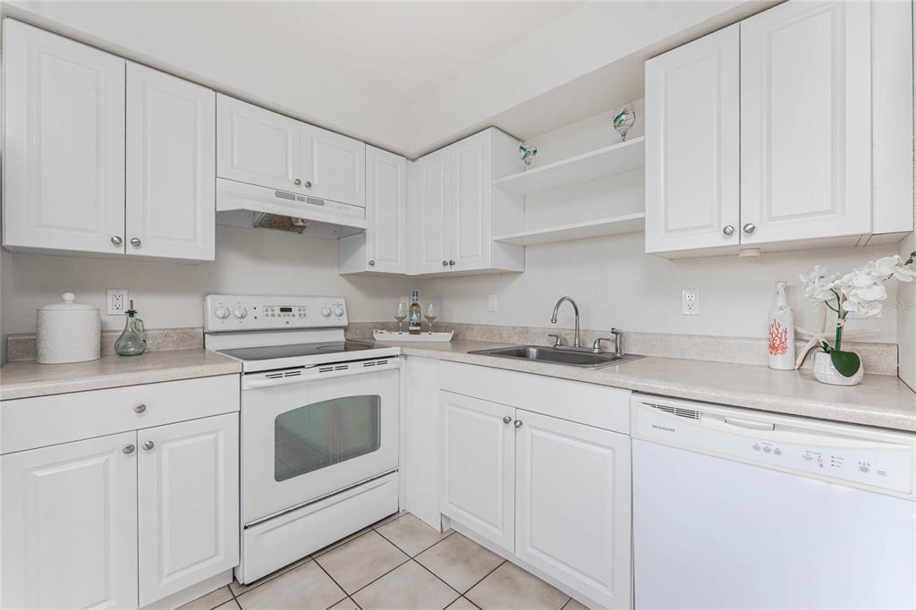 13100 South McCall Road, Unit 191 Port Charlotte, FL 33981 - Photo 15 of 44 a kitchen with white cabinets and white appliances