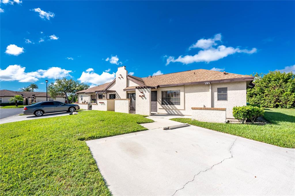 13100 South McCall Road, Unit 191 Port Charlotte, FL 33981 - Photo 2 of 44 a view of a white house with a yard table and chairs