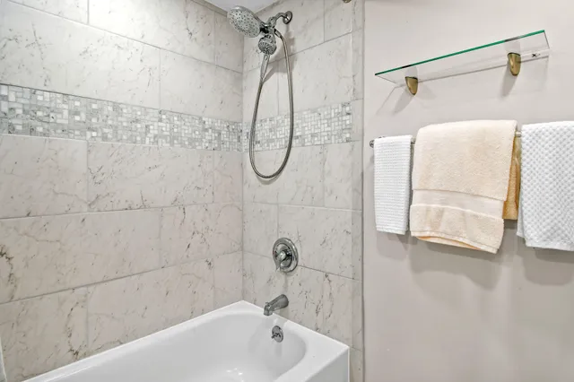 a bathroom with a bath tub with a shower