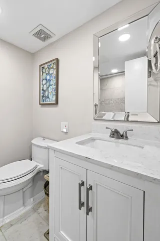 a bathroom with a sink a toilet and mirror