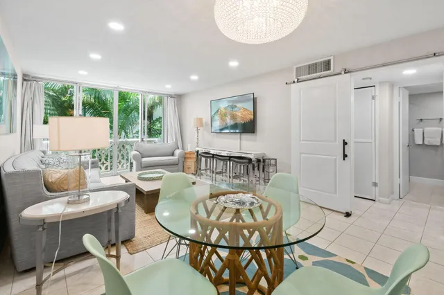 a living room with furniture a dining table and a chandelier